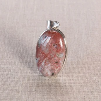 oval shaped agate gemstone with reddish colour. Mounted as a pendant in sterling silver